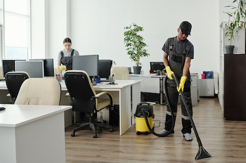 two commercial cleaners working in an office to make it clean