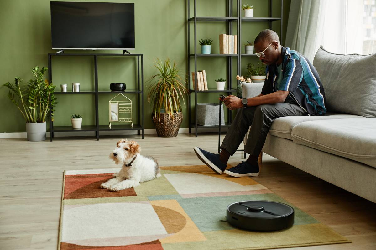 man sat on couch booking apartment cleaning service