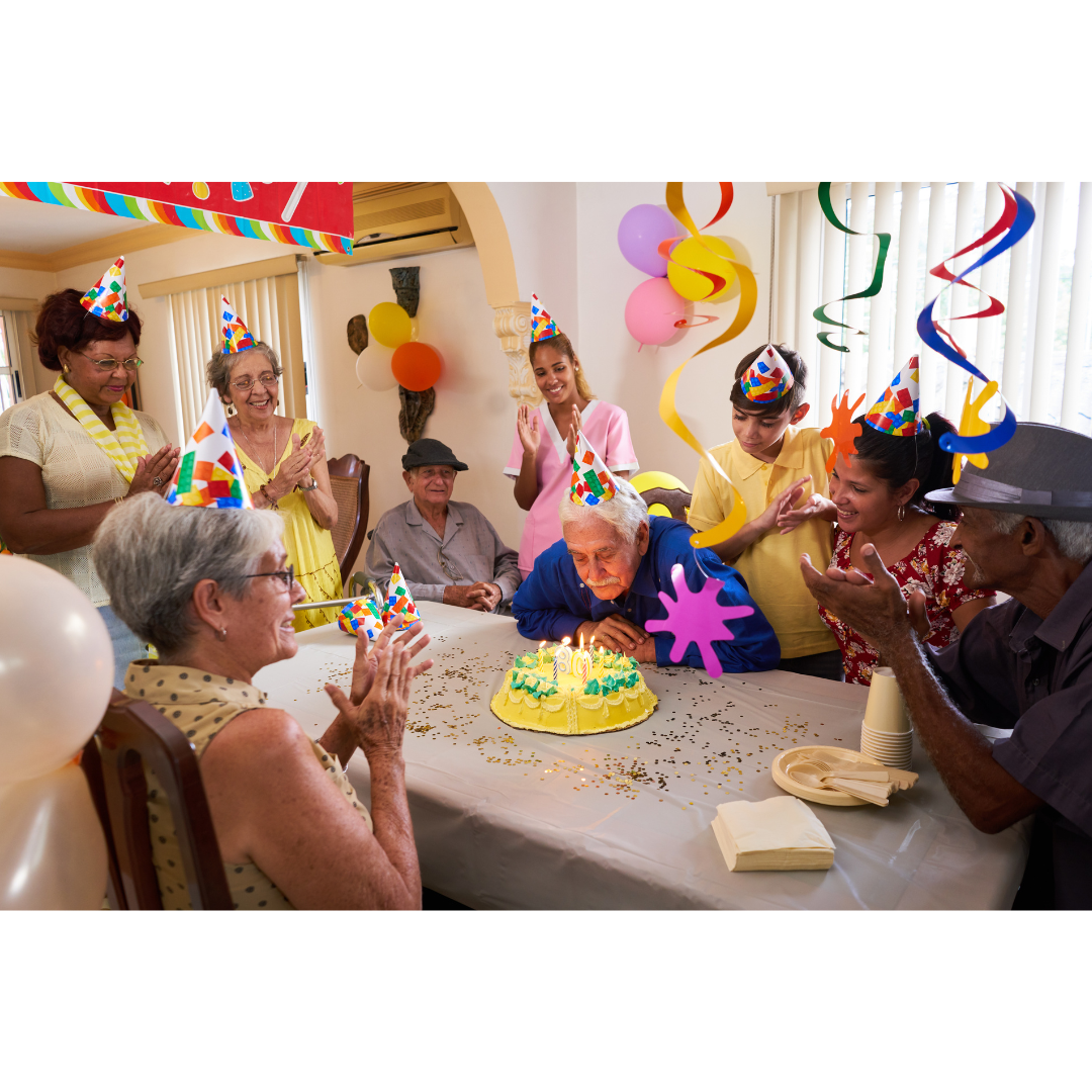 10 people of varying ages attend a birthday party where the older man is seen blowing out candles on a cake.