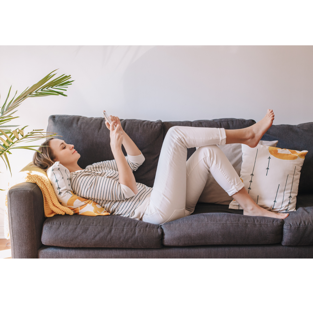 Woman relaxing on her couch in a clean home cleaned by eMaids.