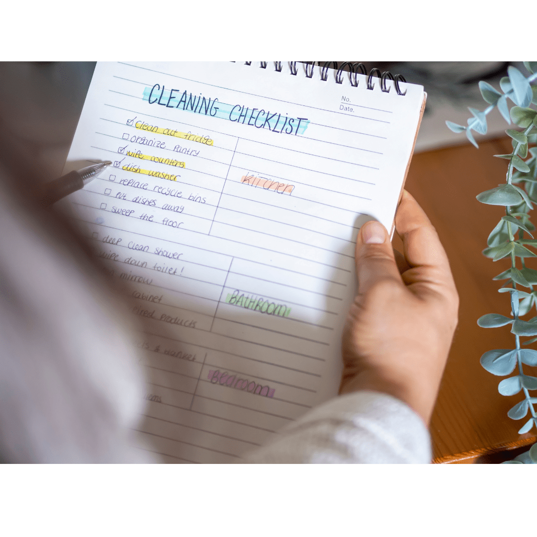 Person holds a cleaning checklist and a pen